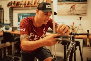 Bike fitter making precise saddle adjustments