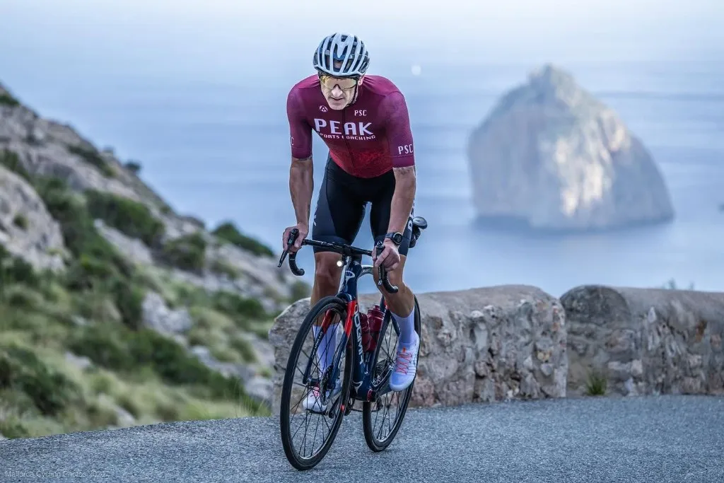 Peak Sports Coaching cyclist riding a coastal road